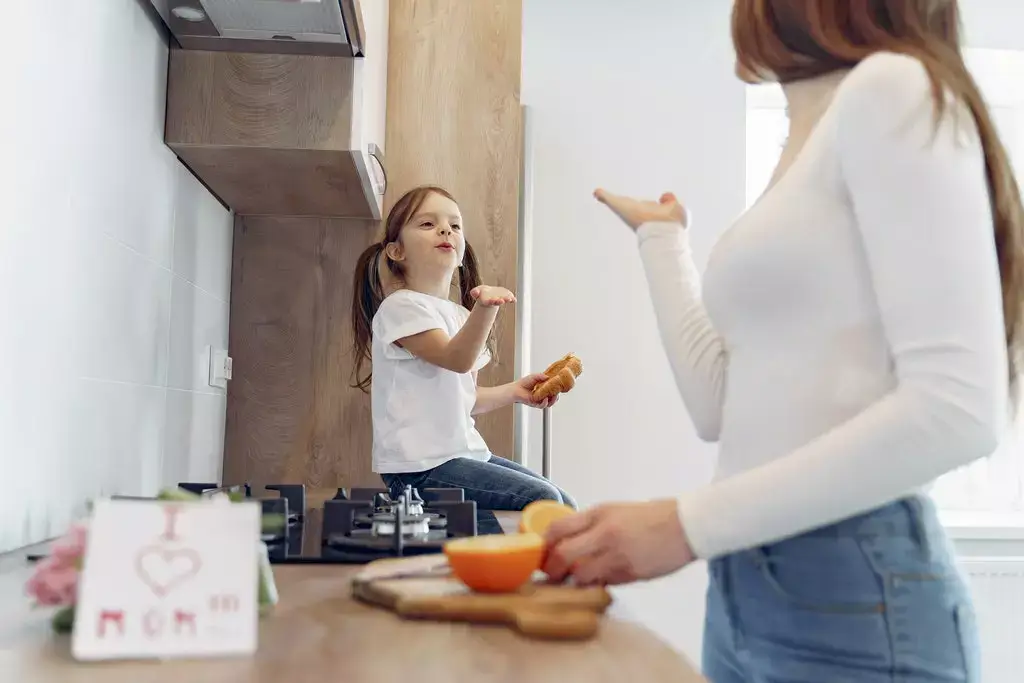 girl and her mum blowing kisses at each other