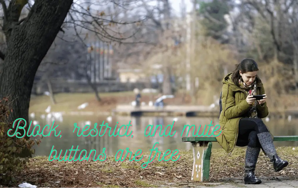 Girl sitting on a bench blocking a guy on her phone as revenge for ghosting her