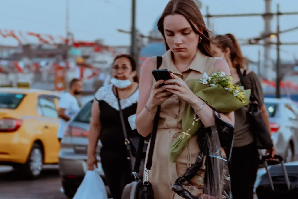 girl walking away while texting on her phone