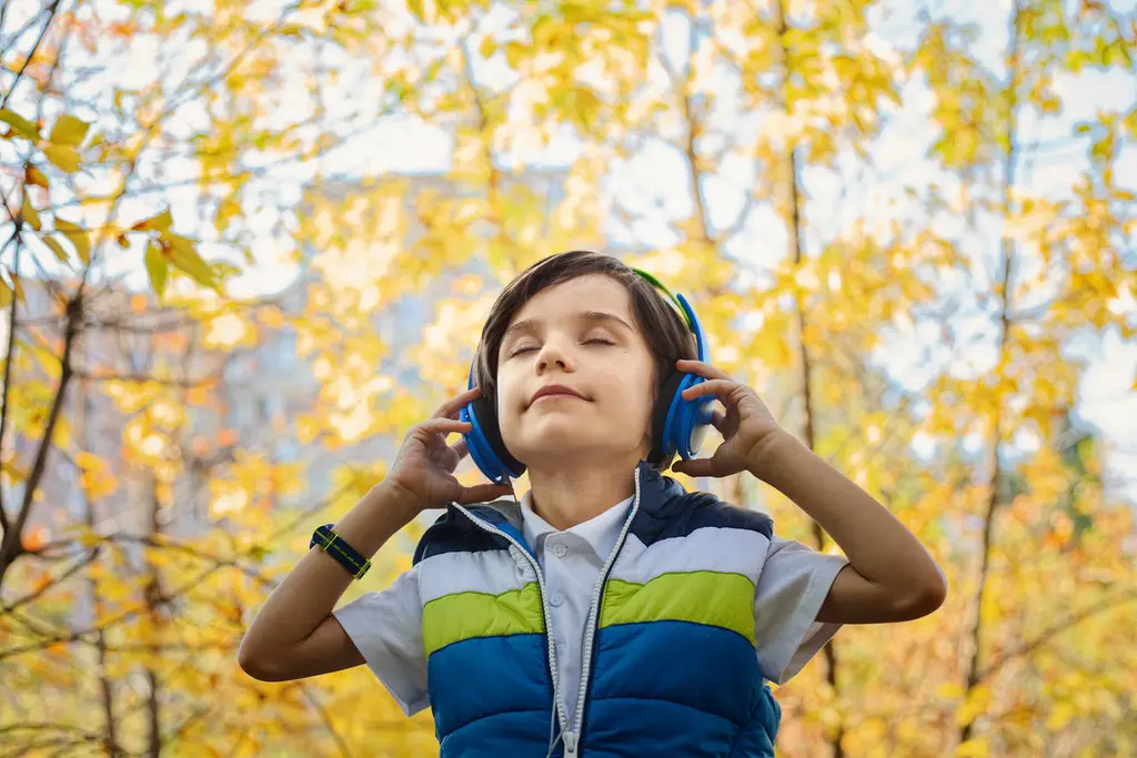 boy listening to music through headphones to ignore someone