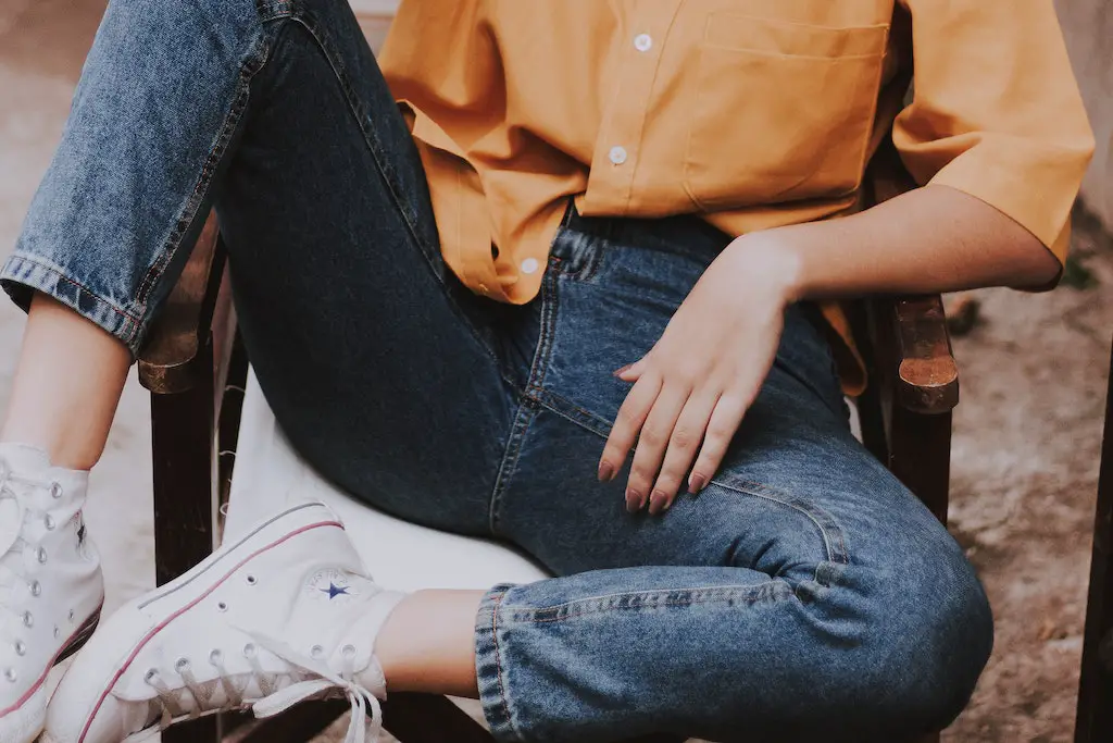 girl sitting on a bench on the side of the road