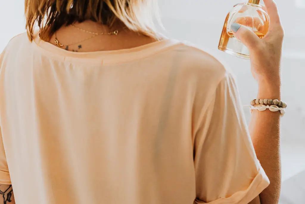 girl spraying antiperspirant