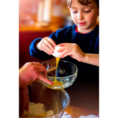 young girl cracking an egg into a bowl