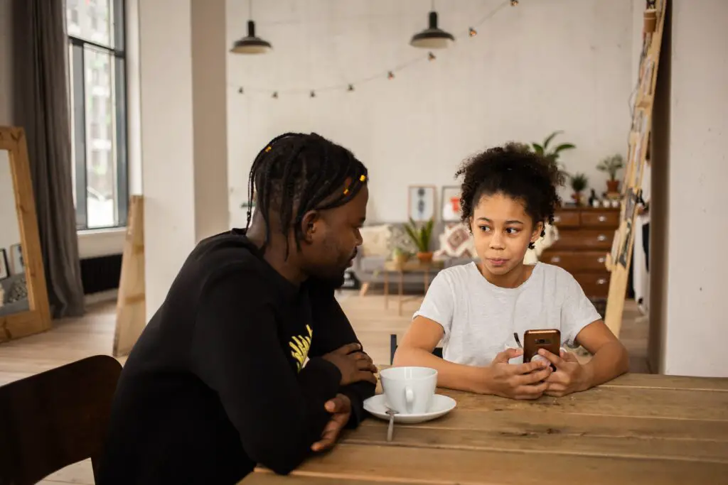 father and daughter talking, while holding phone